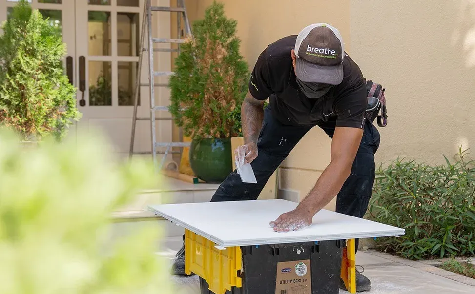 Technician performing maintenance on a residential water tank or related system—highlighting comprehensive home services in Dubai