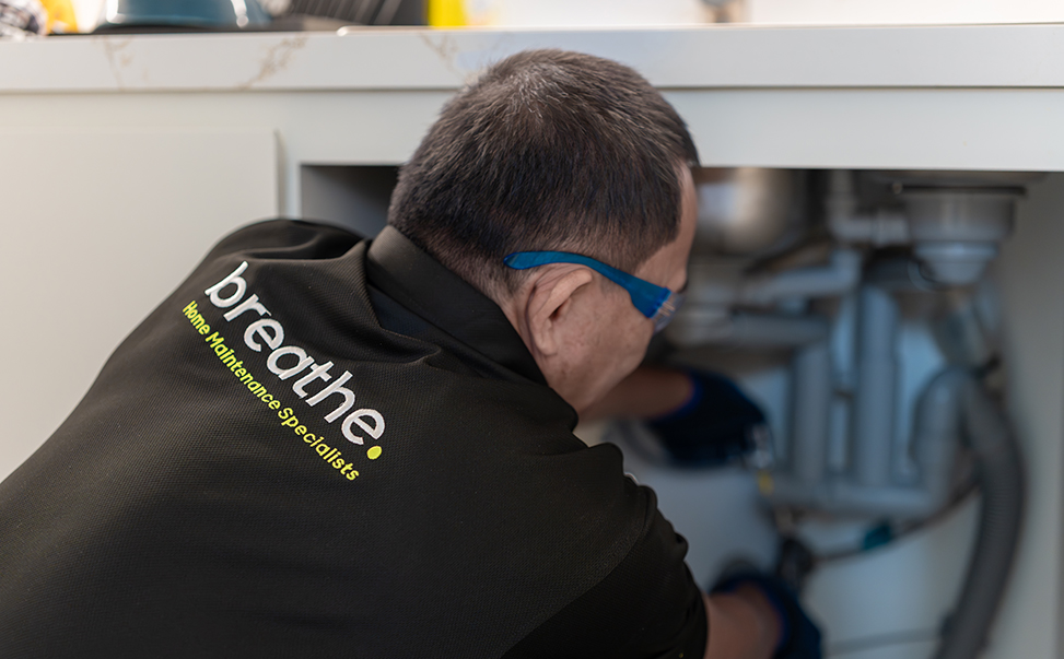 breathe-home-maintenance-specialist-3 Technician performing maintenance on a residential water tank or related system—highlighting comprehensive home services in Dubai